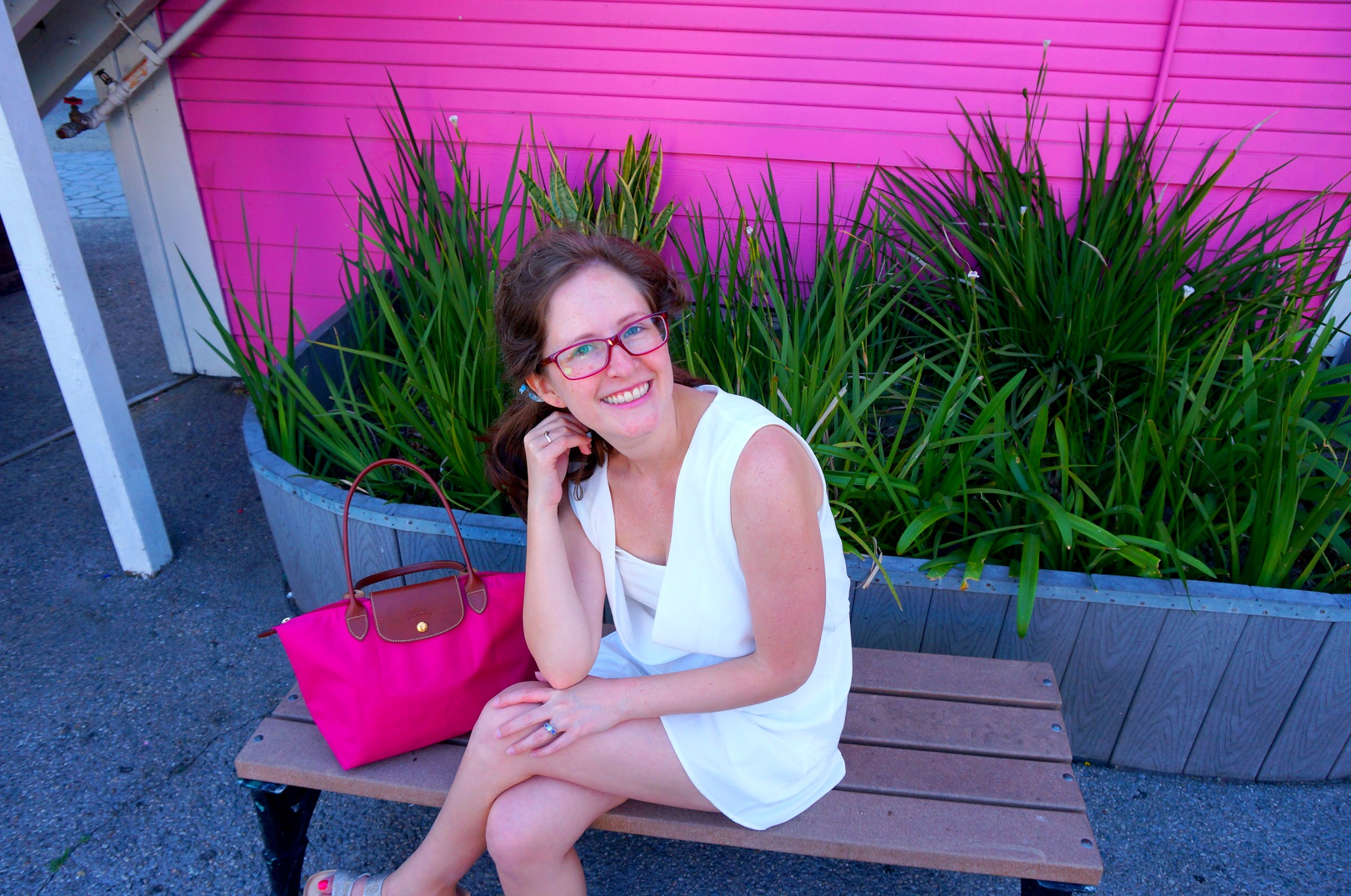 pink-purse-woman-white-outfit-glasses